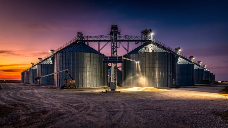 Grain storage facility with solar-powered monitoring at dusk